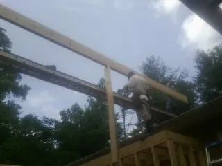 Carpenter setting a ridge beam over a new addition frame — Ice Dam Removal by Roofing Brothers in Mifflintown