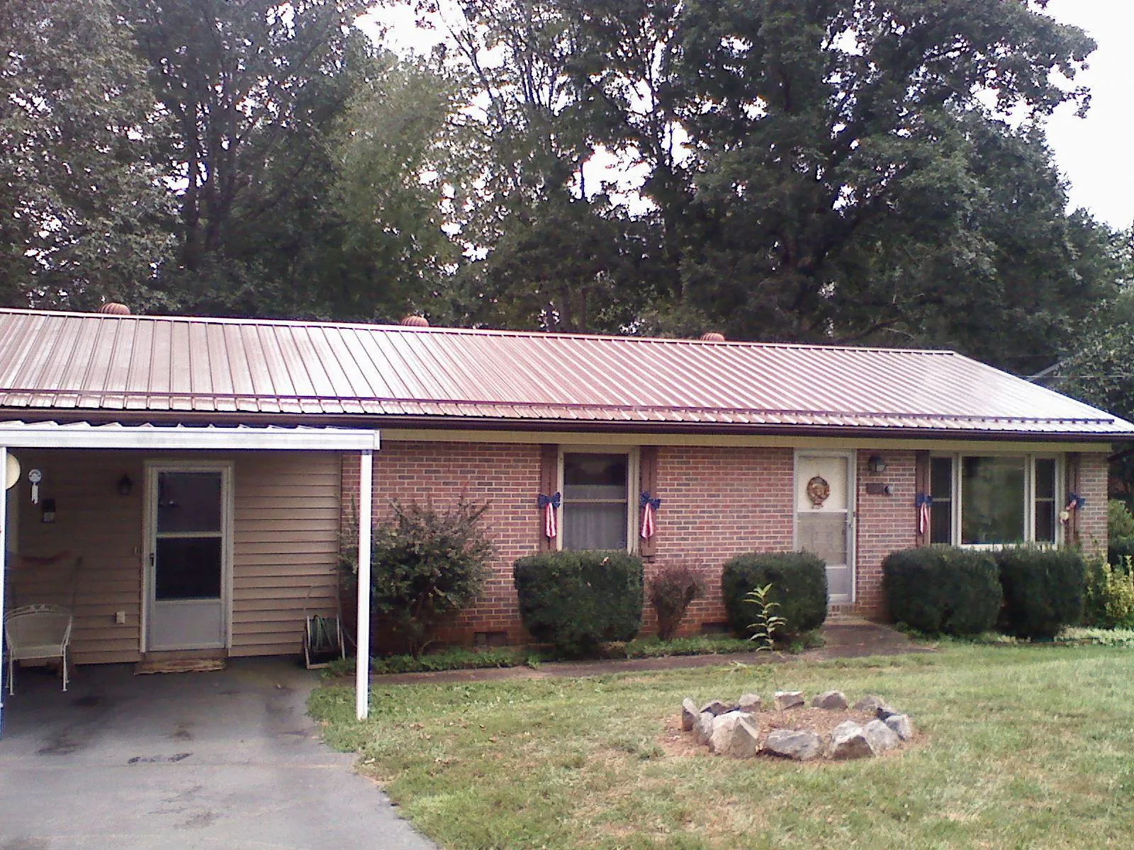 Bronze metal roof and carport on a brick ranch home — Roof Repair work by our crew in Mifflintown